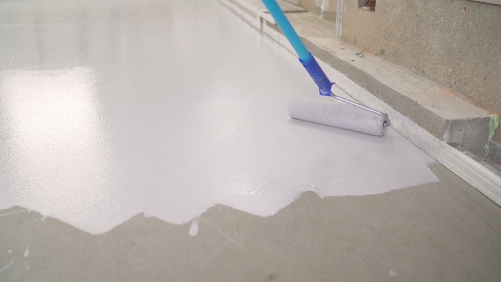 Roller applying a light gray solid color coating